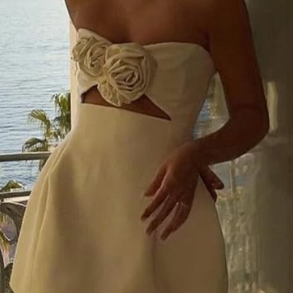 White mini dress with cutouts and rosettes